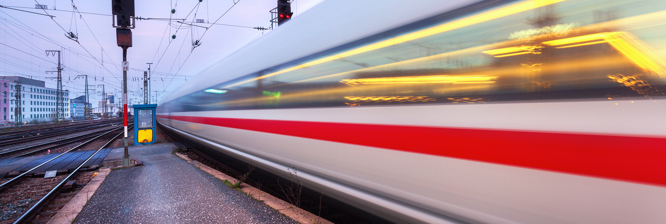 Ein ICE-Zug der Deutschen Bahn fährt aus einem Bahnhof an einem Signalmast vorbei. Foto: © istock.com/den-belitsky