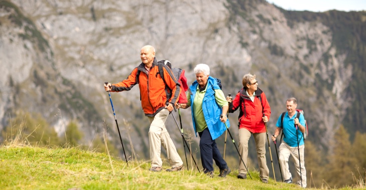 Zwei ältere Frauen und zwei ältere Männern beim Wandern in den Bergen © iStock/amriphoto