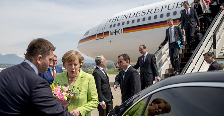 Angela Merkel vor einer Maschine der Flugbereitschaft der Bundeswehr in Sotschi; es steigen weitere Menschen aus der Maschine. | © dpa picture alliance / Michael Kappeler