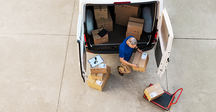 Pakete werden bei einer Lieferung von einem Kurierzusteller in ein Auto geladen. | Foto: © istock.com/Ridofranz